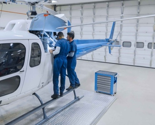Helicopter being worked on by engineers using MGC Aerospace components